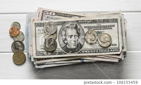 stack of dollar bills and coins stack of dollar bills and coins 108155459