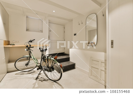 a room with a bike parked next to the door and a mirror hanging on the wall above it that's attached storage space 108155468