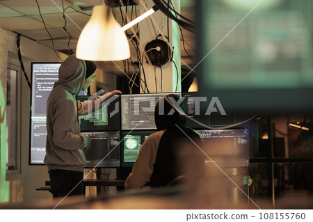 Diverse men working together to break security server, planning data breach with malware and trojan virus. Male hackers doing cyberterrorism attack and stealing passwords, phishing. Diverse men working together to break security server, planning data breach with malware and trojan virus. Male hackers doing cyberterrorism attack and stealing passwords, phishing. 108155760