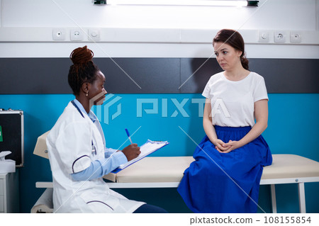 Clinical consultation of patient by doctor looking for illness and pain symptoms. Healthcare woman specialist during checkup in modern hospital offering diagnosis to patient Clinical consultation of patient by doctor looking for illness and pain symptoms. Healthcare woman specialist during checkup in modern hospital offering diagnosis to patient 108155854