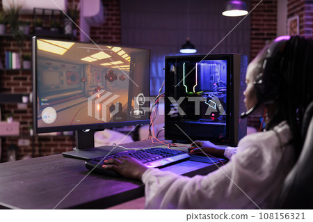 Woman in brick wall living room playing science fiction video game on gaming PC at computer desk, chilling after work. Gamer challenging foes in online multiplayer futuristic shooter 108156321