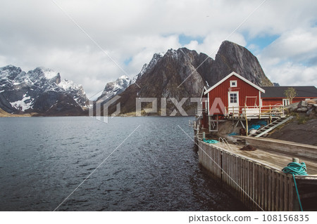 Norway rorbu houses and mountains rocks over fjord landscape scandinavian travel view Lofoten islands. Natural scandinavian landscape. Norway rorbu houses and mountains rocks over fjord landscape scandinavian travel view Lofoten islands. Natural scandinavian landscape. 108156835