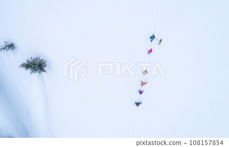 Group of hikers with dog on a mountain trail in winter Group of hikers with dog on a mountain trail in winter 108157854