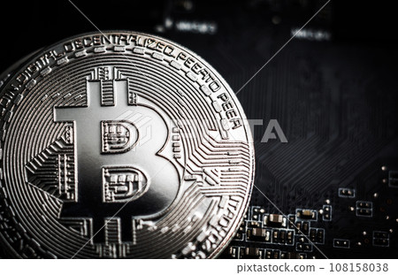 Silver bitcoin on the computer motherboard background Silver bitcoin on the computer motherboard background 108158038