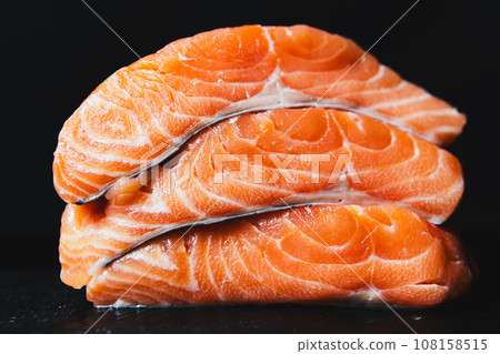 Fresh raw salmon fillet with seasonings and herbs Fresh raw salmon fillet with seasonings and herbs 108158515