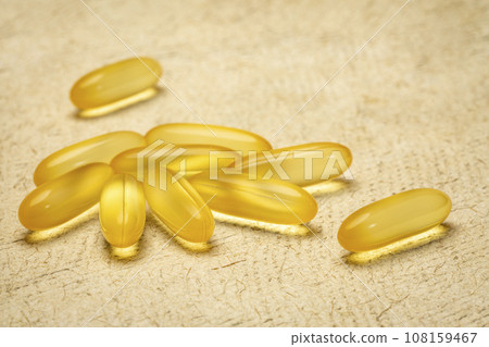 cod liver oil - dietary supplement, a pile of capsules, healthy eating concept 108159467