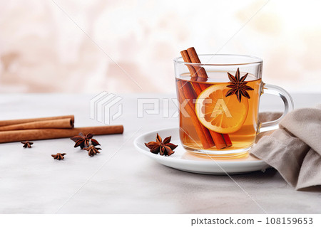 Hot mulled apple cider with with cinnamon sticks, cloves and anise on white wooden table 108159653