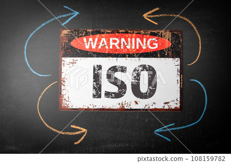 ISO International Organization Standardization. Metal warning sign and colored pieces of chalk on a 108159782