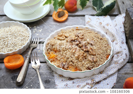 Apricot crumble from oatmeal, walnuts dressing for healthy breakfast Apricot crumble from oatmeal, walnuts dressing for healthy breakfast 108160306