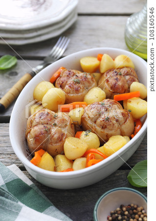 Braised meat paupiettes with potatoes and bell pepper in ceramic bakeware 108160546