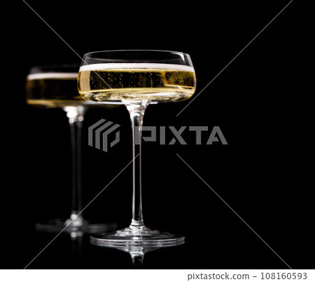 Two champagne glasses on a black 108160593