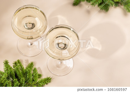 Two champagne glasses on a beige Two champagne glasses on a beige 108160597