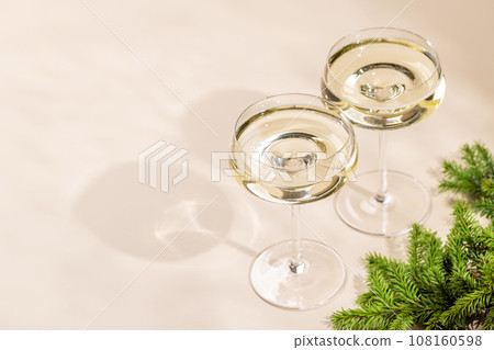 Two champagne glasses on a beige Two champagne glasses on a beige 108160598