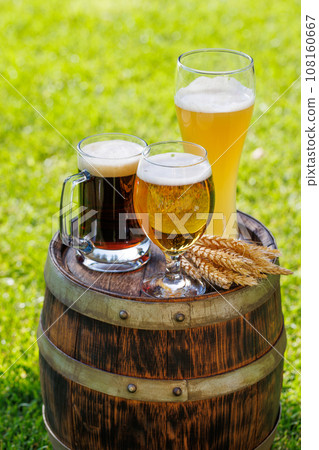 Variety of beer glasses on rustic wooden barrel 108160667
