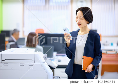 操作智慧型手機的中階女商人 操作智慧型手機的中階女商人 108160814