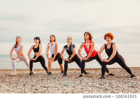 Group of Caucasian women wearing sportswear stretching on beach. Copy space. Concept of outdoor sport Group of Caucasian women wearing sportswear stretching on beach. Copy space. Concept of outdoor sport 108161933