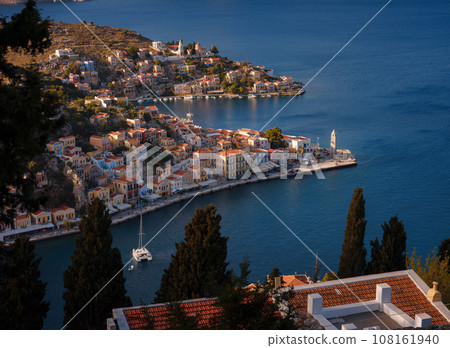 Symi Island, Greece. Greece islands holidays from Rhodos in Aegean Sea. Colorful neoclassical houses in bay of Symi. view of main bay of island, where tourist ferries and yachts moor 108161940