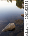 Reflection of waterside rocks and autumn leaves 108162381
