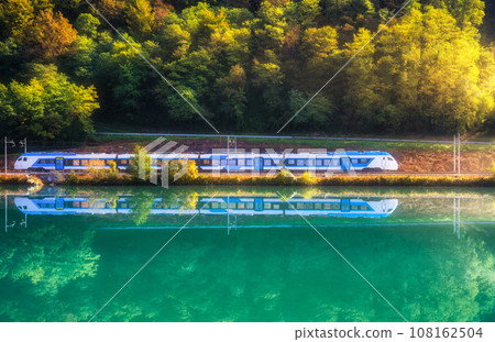 Beautiful blue modern high speed train and river in mountains 108162504