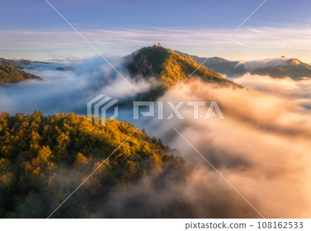 Aerial view of mountain peak in low clouds at sunrise in autumn 108162533