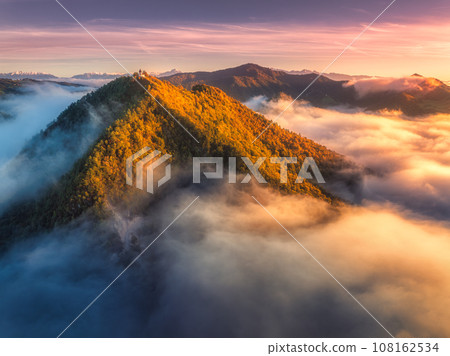 Aerial view of mountain peak in low clouds at sunrise in autumn 108162534