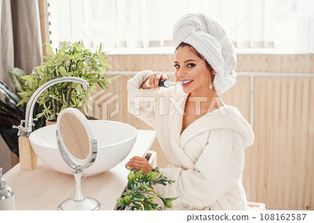 Attractive young woman brush her teeth in bathroom at the morning. Healthcare and beauty concept. 108162587
