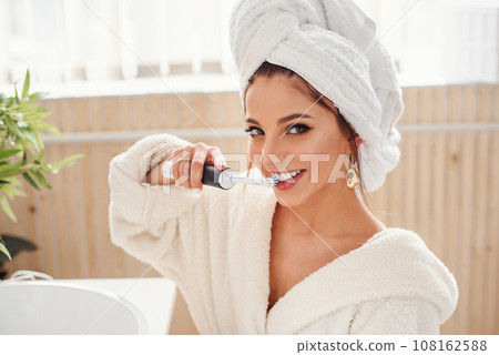 Photo of emotional beautiful young cute woman in bathroom with toothbrush in the hand. 108162588