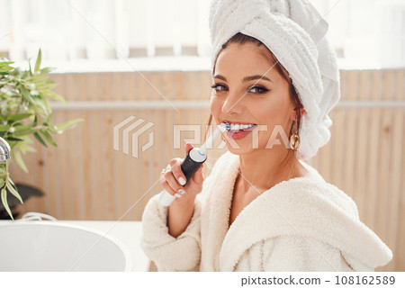 happy beautiful young woman in cozy bathroom with with toothbrush in the hand. Beauty and healt care concept. 108162589