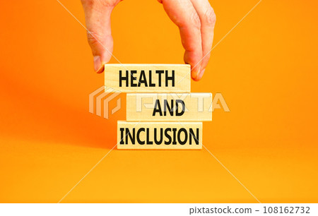Health and inclusion symbol. Concept words Health and inclusion on wooden block. Beautiful orange table orange background. Doctor hand. Business motivational health and inclusion concept. Copy space. 108162732