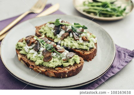 Avocado toast with mushrooms, feta cheese and microgreens Avocado toast with mushrooms, feta cheese and microgreens 108163638