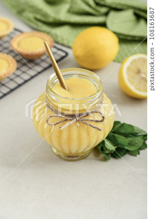 Homemade lemon curd in glass jar with fresh lemons Homemade lemon curd in glass jar with fresh lemons 108163687