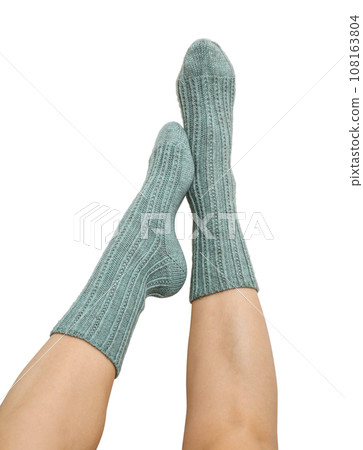 Female legs in blue hand knitted wool socks 108163804
