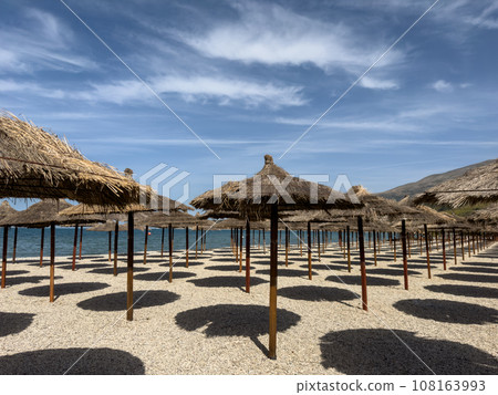 straw beach umbrellas in rows on the beach straw beach umbrellas in rows on the beach 108163993