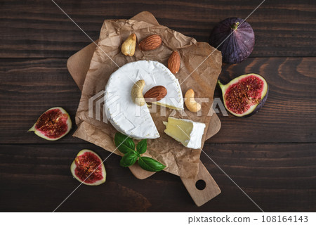 Camembert cheese with fresh figs on cutting board 108164143