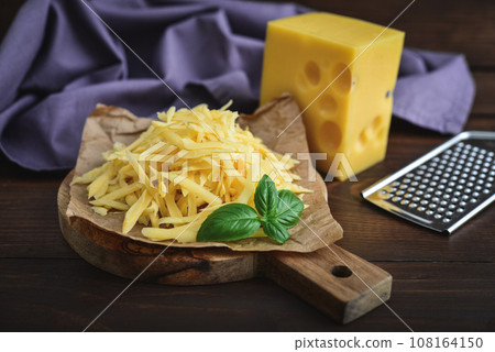 Grated cheese on a cutting board Grated cheese on a cutting board 108164150