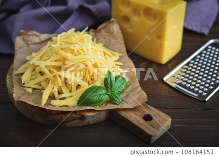 Grated cheese on a cutting board Grated cheese on a cutting board 108164151