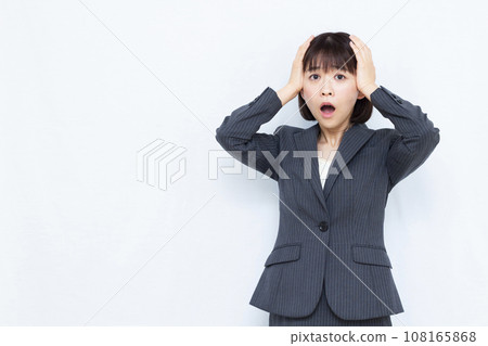 A businesswoman in her 30s holding her head in surprise A businesswoman in her 30s holding her head in surprise 108165868