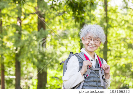 一位快樂的老年人徒步穿越新鮮的綠色植物 108166223