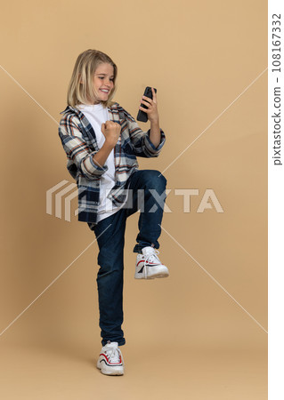 Teen girl with a phone in hands feeling excited and enjoyed 108167332
