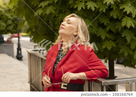 Portrait Relaxed Attractive Business Lady, Mature Sexagenarian Woman with Closed Eyes Outdoor. Stylish Senior Female in her 60s Holds Sunglasses. Boss or Manager Meditates. Horizontal Plane Portrait Relaxed Attractive Business Lady, Mature Sexagenarian Woman with Closed Eyes Outdoor. Stylish Senior Female in her 60s Holds Sunglasses. Boss or Manager Meditates. Horizontal Plane 108168764
