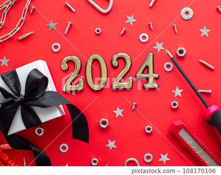 2024 and construction tools and wrapped gift on red background 2024 and construction tools and wrapped gift on red background 108170106