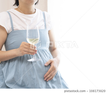 Pregnant woman holding a wine glass filled with wine Pregnant woman holding a wine glass filled with wine 108173820