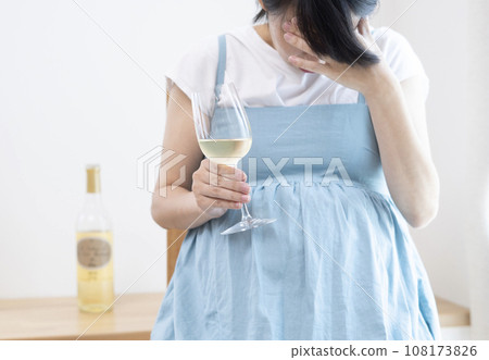酒瓶和孕婦抱著頭拿著一杯酒的圖片 酒瓶和孕婦抱著頭拿著一杯酒的圖片 108173826