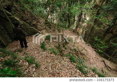 person descending a spiral mountain trail 108175873