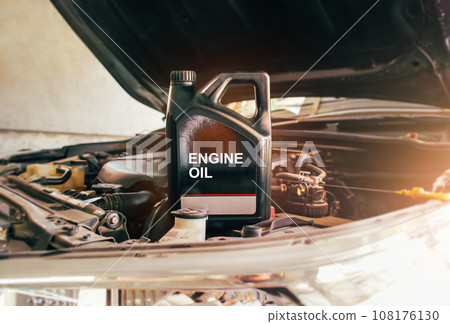 Car engine oil gallon or lubricate oil gallon on car engine compartment with sunlight Car engine oil gallon or lubricate oil gallon on car engine compartment with sunlight 108176130