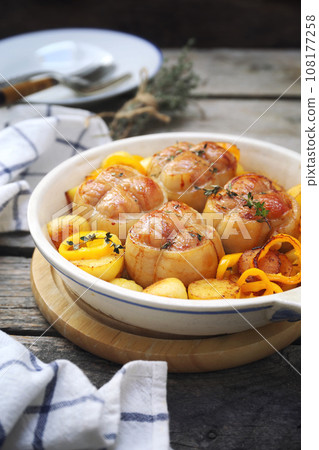 Braised meat paupiettes with potatoes and bell pepper in ceramic bakeware 108177258