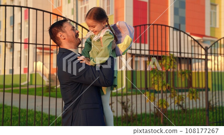 child with school backpack runs into hands his father, school lesson education, daddy care, child hugs his father, child kid daughter flight, playing superhero, happy hug flight, father day, dad child with school backpack runs into hands his father, school lesson education, daddy care, child hugs his father, child kid daughter flight, playing superhero, happy hug flight, father day, dad 108177267