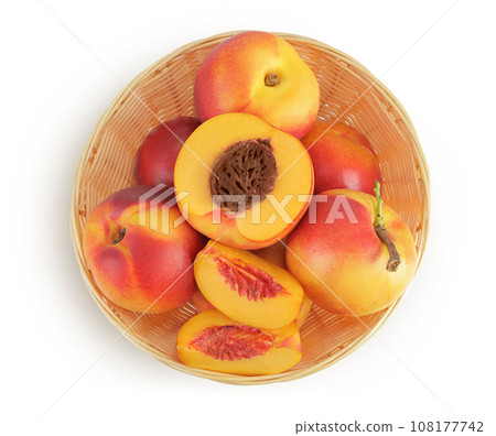 Ripe nectarine fruit with half in a wicker basket isolated on white background with full depth of field. Top view. Flat lay Ripe nectarine fruit with half in a wicker basket isolated on white background with full depth of field. Top view. Flat lay 108177742