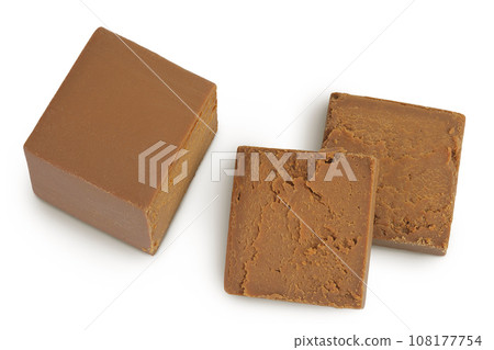 Brown cheese. Norwegian brunost isolated on white background. Top view. Flat lay 108177754