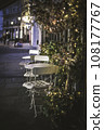Bistro tables, lining the pavement of a city, on a summers evening, surounded by small fairy lights to create atmosphere 108177767